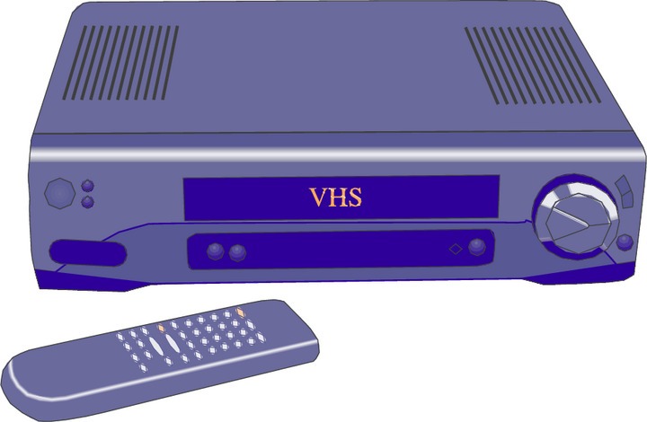 VHS player with a purple remote control placed nearby, front panel and dial visible