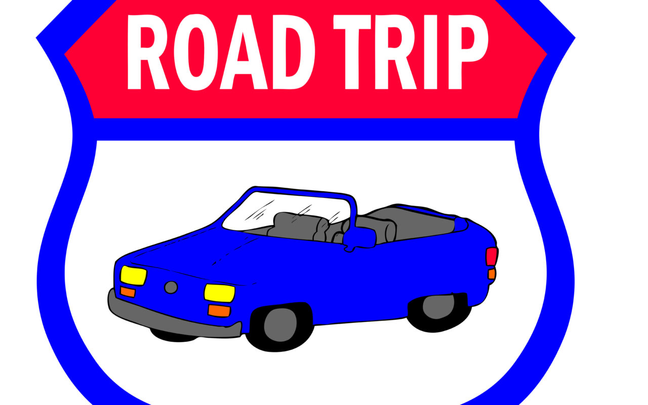 Shield-shaped sign with a blue convertible and a red banner that reads ROAD TRIP, indicating travel theme.