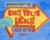 Bright yellow arrow sign advertising Waukesha County Fair with 'Get Your Kicks!' and July 15–19 against a blue sky.